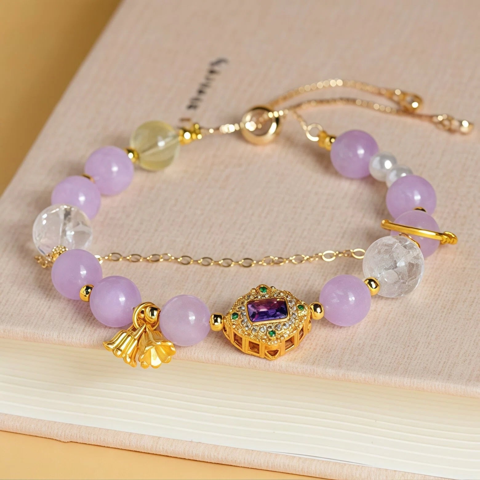 Styled flat lay of Aries Zodiac Bracelet resting on a book. Featuring 8mm Lavender Amethyst and Citrine beads with 5mm Pearl accents for intellectual energy - Kosmos Zen