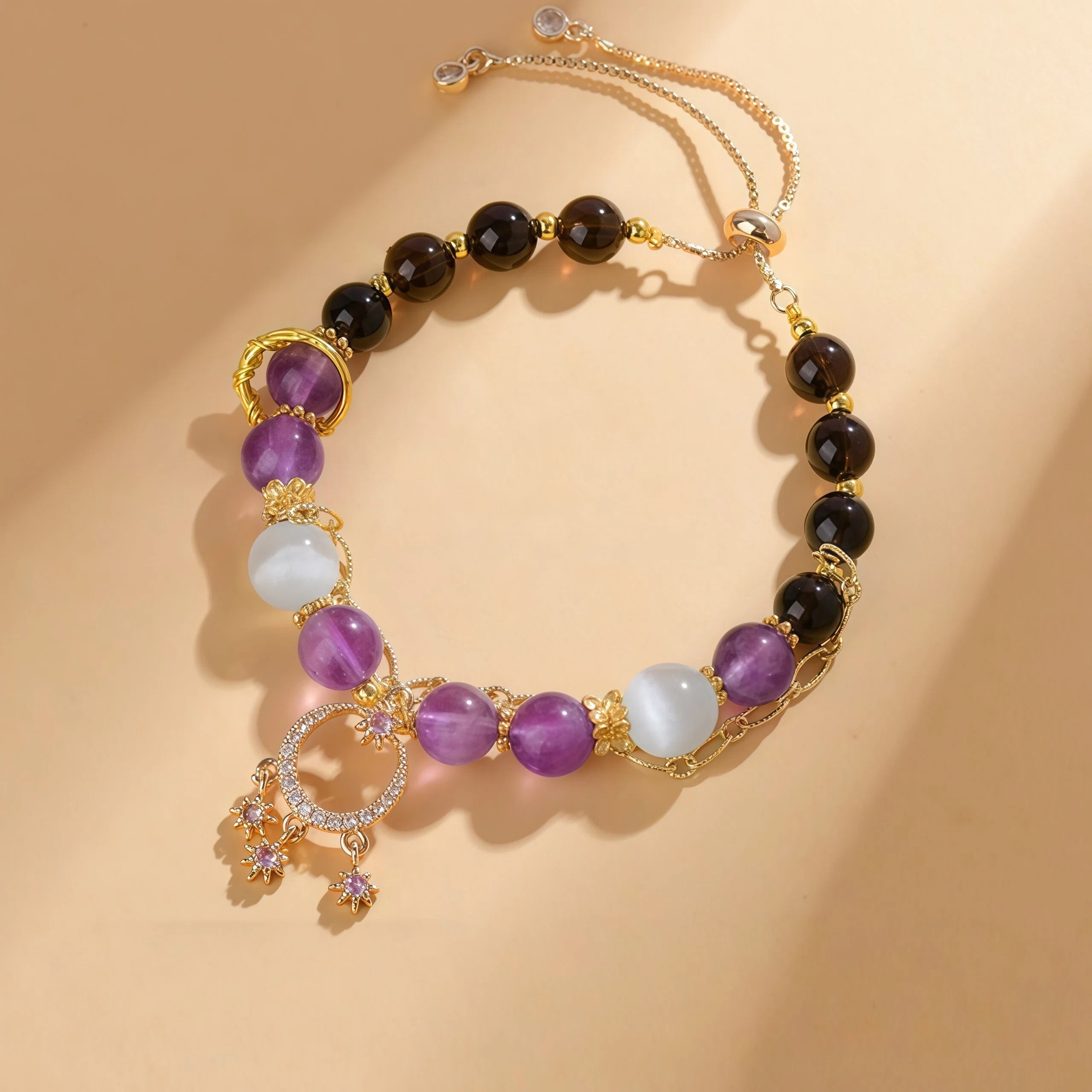 Capricorn Zodiac Bracelet featuring 10mm Cat's Eye, 9mm Amethyst, and 7mm Smoky Quartz beads. Gold grounding jewelry for stability with a jeweled Celestial Star charm - Kosmos Zen
