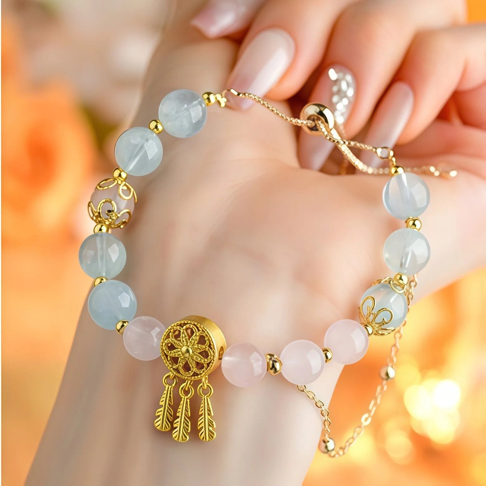 Elegant on-hand view of Pisces Zodiac Bracelet featuring 9mm Rose Quartz and Aquamarine beads. Close-up detail of the gold Dreamcatcher charm with dangling feathers for emotional flow - Kosmos Zen
